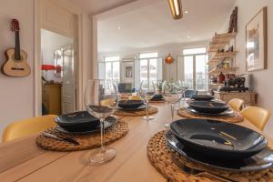 a table with plates and wine glasses on it at Fantastic Family Apartment in Estrela in Lisbon