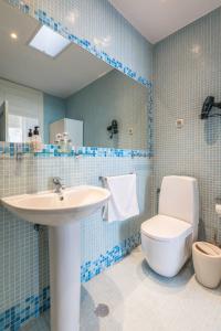 a blue tiled bathroom with a sink and a toilet at Fantastic Family Apartment in Estrela in Lisbon