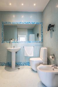 a blue tiled bathroom with a toilet and a sink at Fantastic Family Apartment in Estrela in Lisbon
