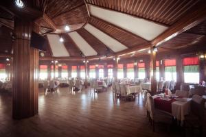 uma sala de jantar com mesas e cadeiras brancas em Hotel Insula em Tulcea