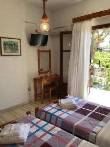 a bedroom with a bed and a window and a mirror at Arillas Studios in Arillas