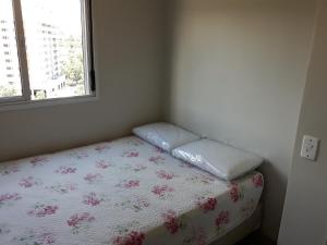 a small bedroom with a bed with a window at Apto prox. BR470 in Bento Gonçalves