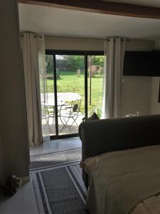 a living room with a door open to a patio at Chambre d’hôte - Ilse's Garden Chair in La Porcherie