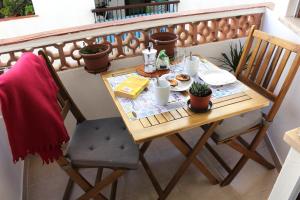 einen Holztisch mit Essen auf dem Balkon in der Unterkunft Cubo in Lagos