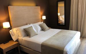 a bedroom with a large white bed with two pillows at Hotel Windsor in Tossa de Mar