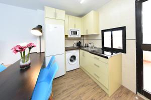 a small kitchen with a table and a refrigerator at Zenbeach 1A playa carihuela in Torremolinos