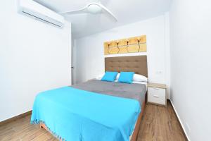 een slaapkamer met een bed met blauwe lakens en een raam bij Zenbeach 1A playa carihuela in Torremolinos