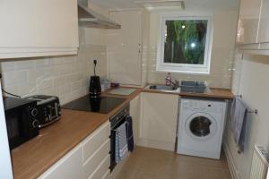 a kitchen with a washing machine and a sink at Pageant Lodge in Telford