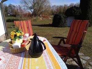 a table with a vase of flowers and two chairs at Ferienhaus Ringelwiese in Schönstedt