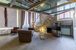 ミラノにあるDesign Suite in Corso Comoのリビングルーム(ソファ、テレビ付)