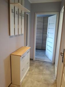 a room with a white dresser and a door at Apartament Nad Dziwną in Dziwnów