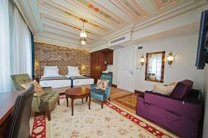 イスタンブールにあるAzade Premier Hotelのベッドとソファ付きのホテルルーム