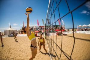 a woman hitting a volleyball on a beach at Leo Canela in Isla Canela