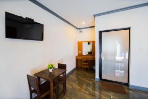 a dining room with a table and a television on a wall at Numjaan Resort in Krabi town