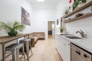 uma cozinha com um lavatório e um balcão com bancos em Su Casa at Venice Beach em Los Angeles