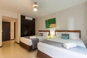 a hotel room with two beds and a balcony at Via Tendenza Condos in Playa del Carmen