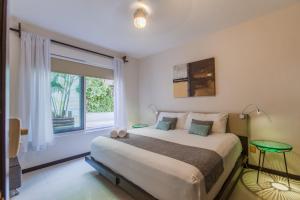 a bedroom with a large bed and a window at Via Tendenza Condos in Playa del Carmen