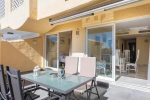 une table et des chaises en verre sur la terrasse dans l'établissement Magnifico apartamento con vistas en Puerto Marina, à Benalmádena