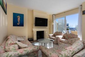 ベナルマデナにあるMagnifico apartamento con vistas en Puerto Marinaのリビングルーム(ソファ2台、テレビ付)