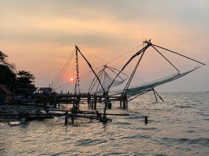 a boat on a dock in the water at sunset at Sea View Apartments in Cochin