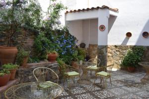 eine Terrasse mit Stühlen, Tischen und Blumen in der Unterkunft Hostal Rural Molino Del Bombo in Aracena
