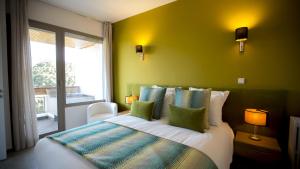 een slaapkamer met een bed met groene muren en een raam bij Balima Minaret Suites in Rabat