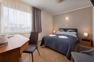 - une chambre avec un lit, un bureau et une fenêtre dans l'établissement Willa Ariadna, à Jastrzębia Góra