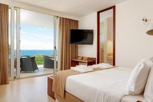 a bedroom with a bed and a view of the ocean at Sao Rafael Holidays in Albufeira