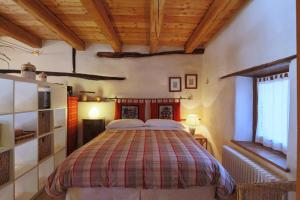 a bedroom with a bed in a room with wooden ceilings at Monolocale Gemma Locanda Codirosso in Stroppo