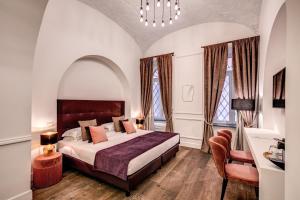 ローマにあるブティック チェントラーレ ルレのベッドルーム1室(大型ベッド1台、窓2つ付)