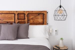 Schlafzimmer mit einem Bett mit einem Kopfteil aus Holz in der Unterkunft GOMEZ ROOMS in Xàtiva