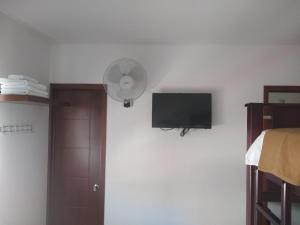 a room with a fan and a tv on a wall at Hotel Don Luis in Ocaña