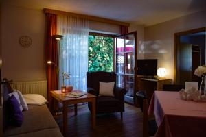- un salon avec un canapé, une table et une fenêtre dans l'établissement Appartementhaus Sibylle, à Bad Füssing