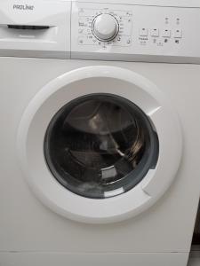 a white washing machine with its door open at Strand zuid in Egmond aan Zee