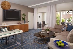a living room with a couch and a tv at Naples Grande Beach Resort in Naples
