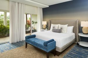 a bedroom with a bed and a blue chair at Naples Grande Beach Resort in Naples