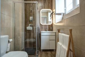 een badkamer met een douche, een toilet en een wastafel bij Loulé Coreto Guesthouse in Loulé