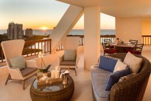 a balcony with two couches and a table on a balcony at Naples Grande Beach Resort in Naples