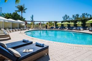 a large swimming pool with lounge chairs and umbrellas at Naples Grande Beach Resort in Naples