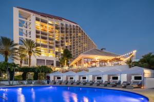a hotel with a swimming pool in front of a building at Naples Grande Beach Resort in Naples