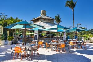 an outdoor patio with tables and chairs with umbrellas at Naples Grande Beach Resort in Naples
