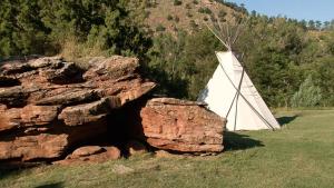 a white tent next to a rock in a field at Allen Ranch in Hot Springs