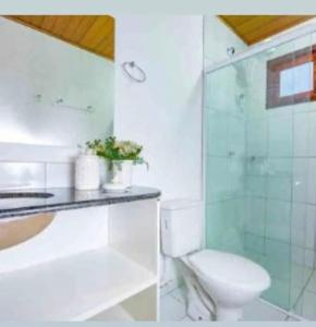 a bathroom with a toilet and a glass shower at Chale´Ville Charme 902 in Luis Correia