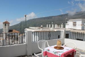 a table and chairs on a balcony with a view at Manzanilla Real in Capileira