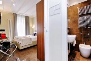 una camera da letto con un letto e un bagno con un lavandino di Piazza Venezia Grand Suite a Roma