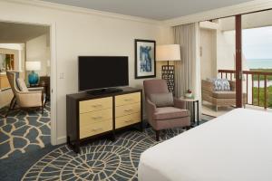 a hotel room with a bed and a television at Naples Grande Beach Resort in Naples