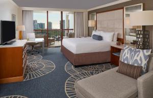 a hotel room with a bed and a desk and a television at Naples Grande Beach Resort in Naples