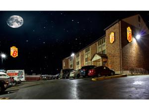 a street with cars parked in a parking lot at night at Super 8 by Wyndham St Charles in St. Charles