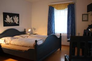 a bedroom with a bed and a window with blue curtains at Sohre in Hamburg +23 photos