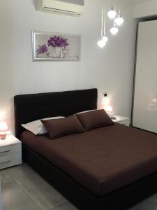 ein Bett in einem Schlafzimmer mit zwei Nachttischen und zwei Lampen in der Unterkunft Rooms Suite Silvy in Civitanova Marche